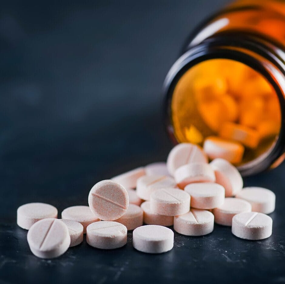 White Medical Pills Or Tablets With Bottle On Black Background.